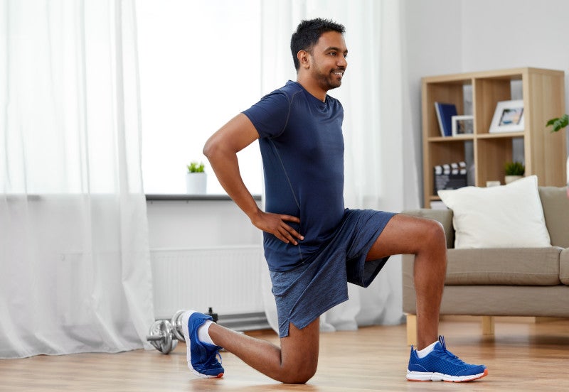 indian man exercising and doing squats at home