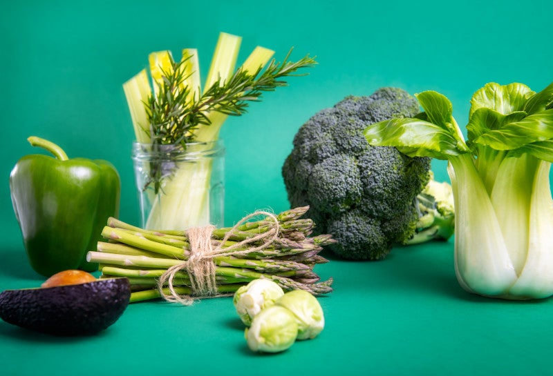 An assortment of green vegetables on a green background showing that nutrition can be one intervention that may help type 1 diabetes.