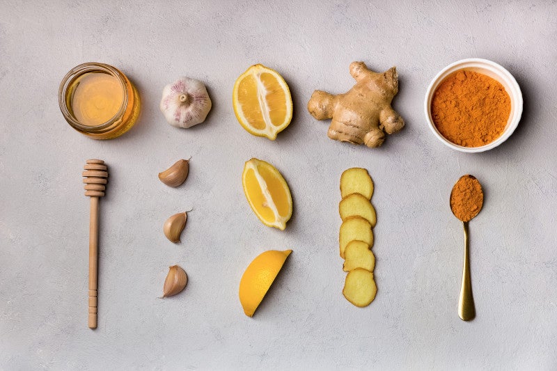 Flat lay of anti-inflammatory herbal medicines ginger, garlic, turmeric, honey, lemon. These herbs support the immune system and may help with Mast Cell Activation.