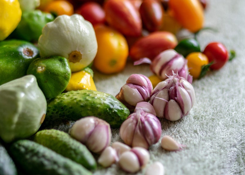 Primer plano de coloridas verduras otoñales sobre una mesa de piedra que muestra que la nutrición y los micronutrientes pueden ayudar a combatir los problemas de salud mental y las enfermedades crónicas.