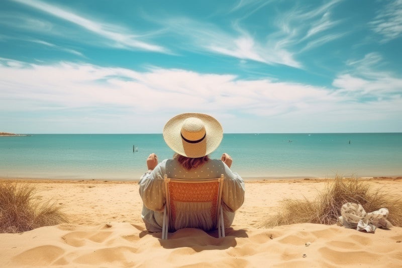 Back profile of a woman in a hat relaxing in a beach chair enjoying the view of the ocean and clouds. She is relaxed because using functional medicine has helped her cardiometabolic condition by reducing her lipid burden.
