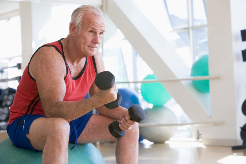 Elderly person lifting weights at rehab