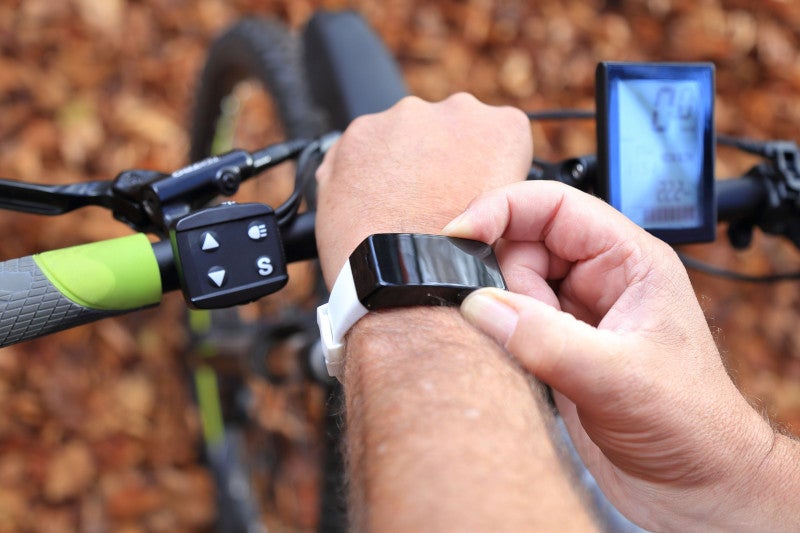 person using smart watch while on a bike ride