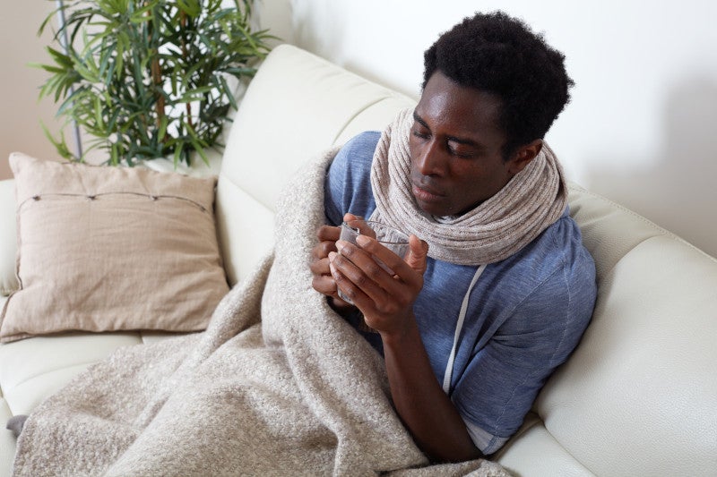 sick man cuddling blanket