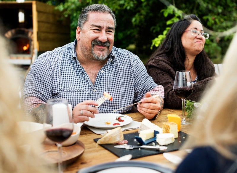 Group of people dining outside together and eating nutritious food to combat early on-set dementia.