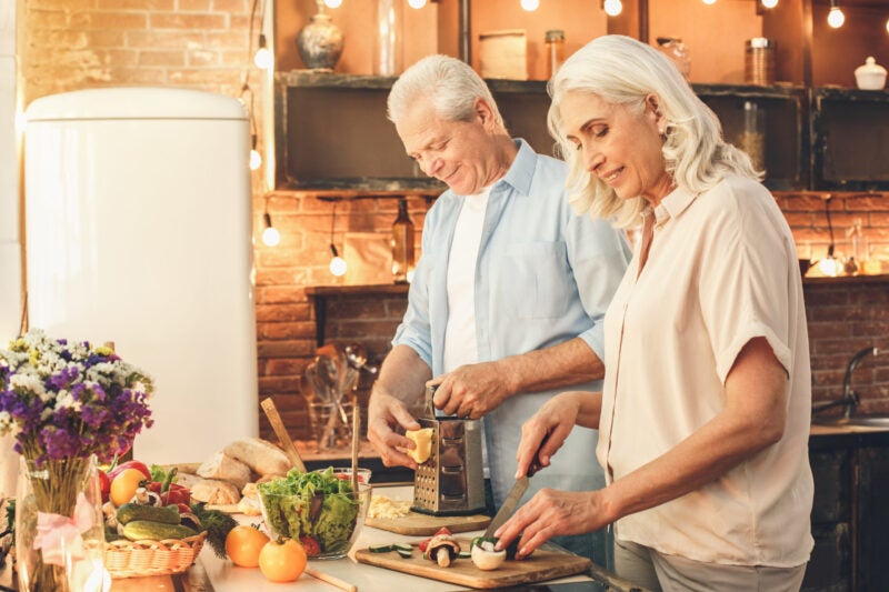 Senior couple cooking together at home meal preparation