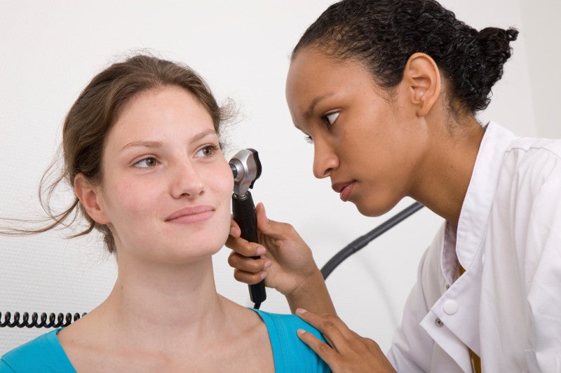 Doctor looking into her patients ears with an instrument