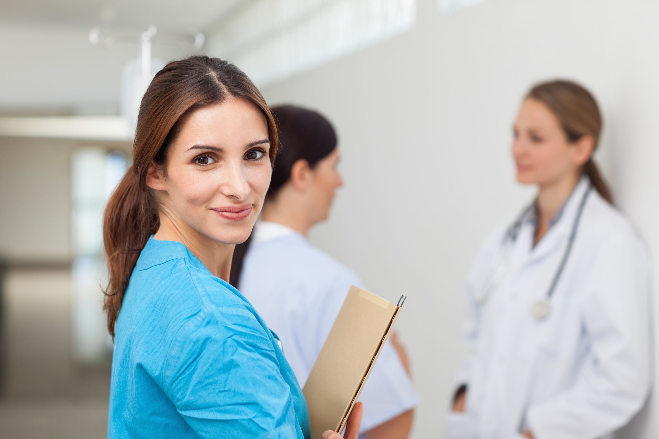 Female healthcare professional, doctors in background