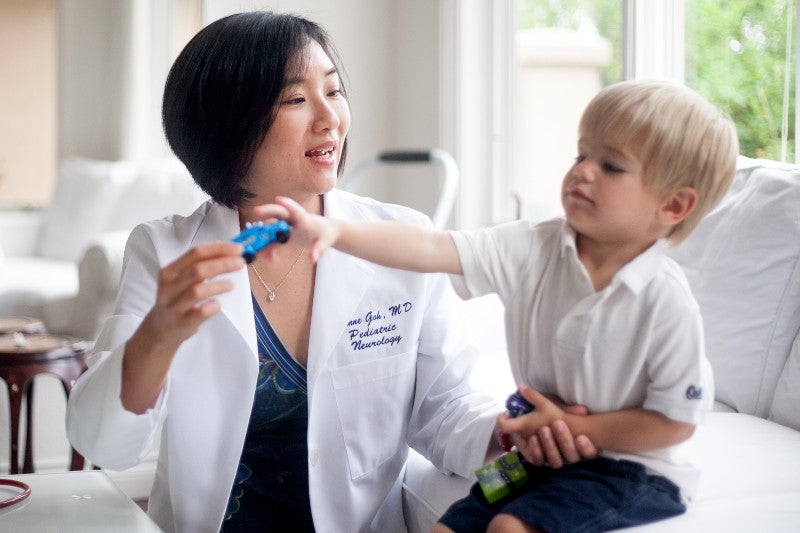 Suzanne Goh, MD working with autistic child
