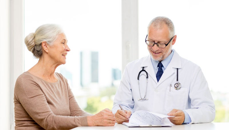 smiling senior woman and doctor meeting in medical office